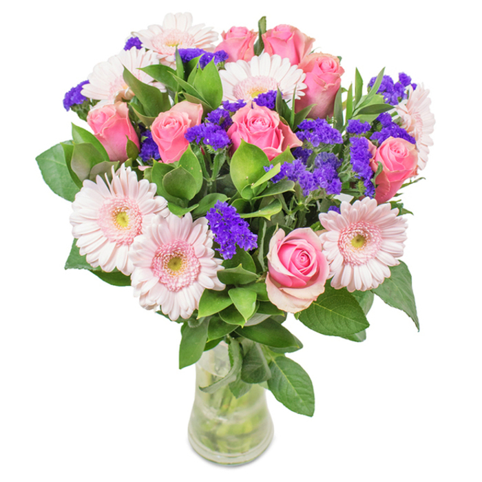 An exquisite bouquet thoughtfully crafted in Harold Park, this arrangement centers around approximately 7-9 pink roses, their soft to medium blush petals classic in form-some just starting to reveal their intricate spiral shape, others still shyly closed. Intertwined with about 5-7 pale pink gerbera daisies, whose large daisy heads and almost-whitened centers glisten in natural light, the bouquet draws the eye with its elegant contrast. Vivid pops of purple statice, reminiscent of the wild summer blooms seen near Harold Wood Park, punctuate the arrangement, while lush, deep green foliage creates a verdant, restorative foundation. The clear glass vase allows a glimpse of water and crisp, fresh-cut stems, reaffirming a promise of longevity and care so often associated with fresh local flower delivery in Harold Park. Perfect for birthdays, anniversaries, or simply expressing thoughtful affection, this arrangement conveys a tailored sense of joy, warmth, and connection to the surrounding community. Every element-colour, texture, and composition-speaks of expert craftsmanship and deep-rooted local pride.